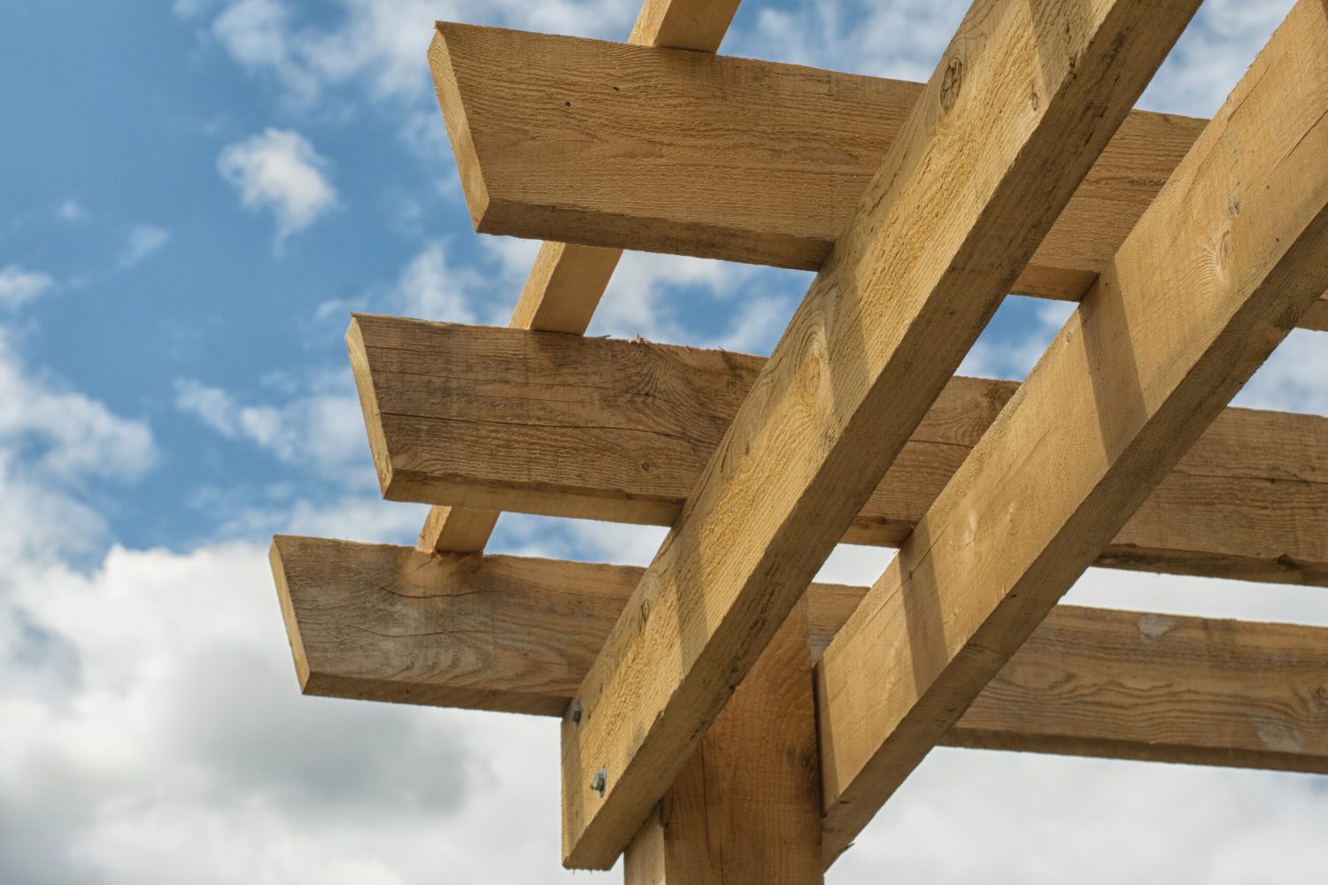 Closeup,Shot,At,The,Corner,Of,A,Wooden,Pergola,Against
